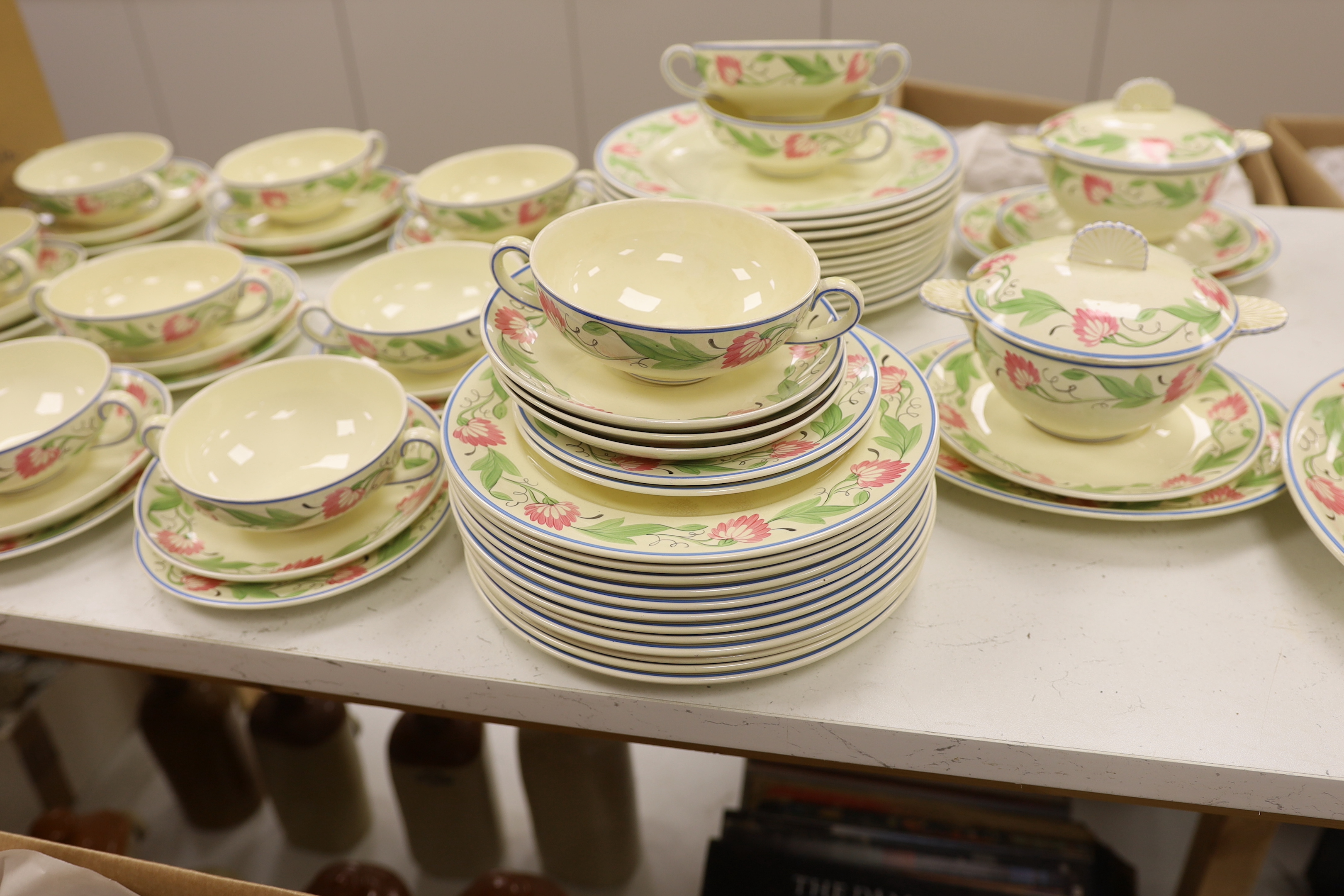 A Wedgwood floral pattern dinner service, c.1934 including twin handled cups, dinner plates and serving dishes, largest 42cm wide